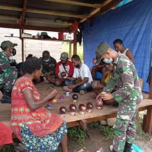 TNI Ajarkan Pembuatan Batok Kelapa menjadi Celengan Hias di Kampung Mosso Papua